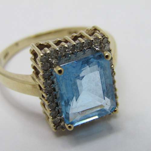 9kt Gold ring with 3.5ct blue topaz and small diamonds of 0.28ct in total - weighs 4.8g - size O/7