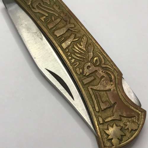 Vintage pocket knife with brass handle and hunting theme