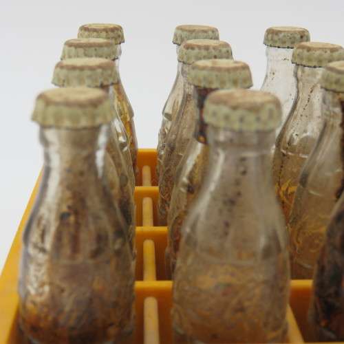 Vintage miniature Coca-Cola bottles in yellow tray - Two Coke bottles missing and was replaced