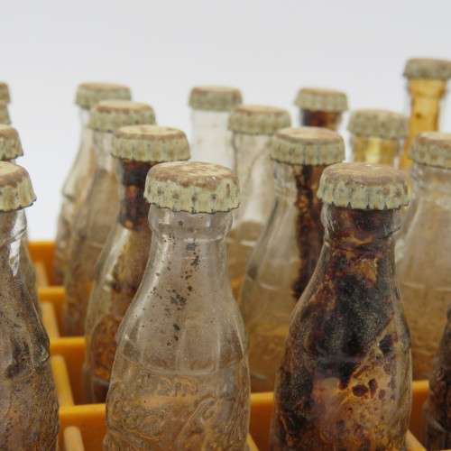 Vintage miniature Coca-Cola bottles in yellow tray - Two Coke bottles missing and was replaced