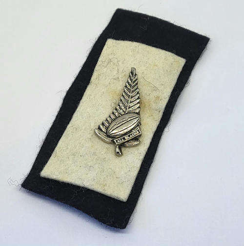 Vintage All Blacks New Zealand rugby pin badge on felt background