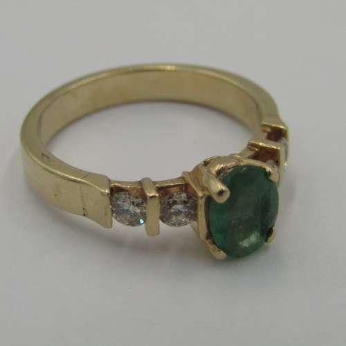 14kt Yellow Gold ring with 4 diamonds totalling 60 points SI / G and emerald of 95 points