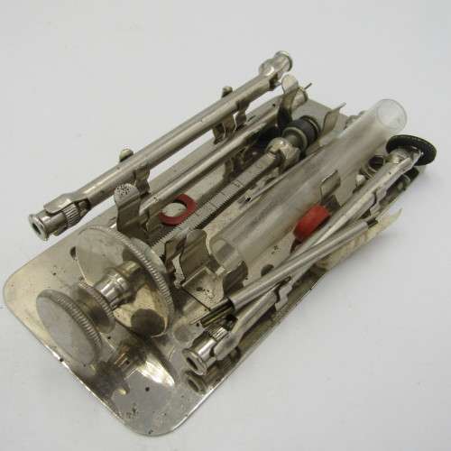 Vintage glass syringe set in metal tin