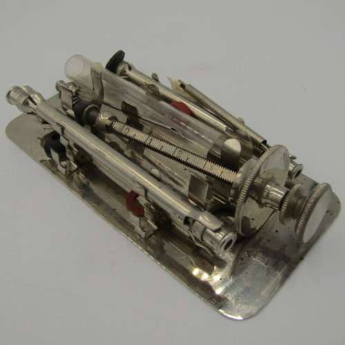Vintage glass syringe set in metal tin