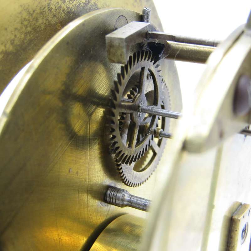 Antique brass skeleton clock with glass dome