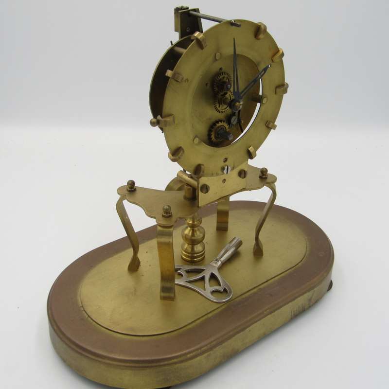 Antique brass skeleton clock with glass dome