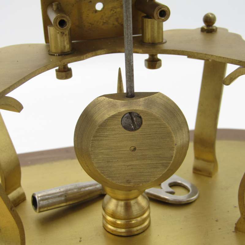 Antique brass skeleton clock with glass dome