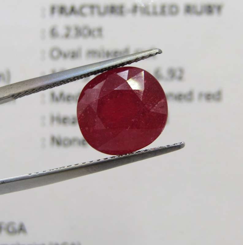 Fracture filled Ruby of 6,2 carat oval mixed cut - dark toned red with Gemlab certificate