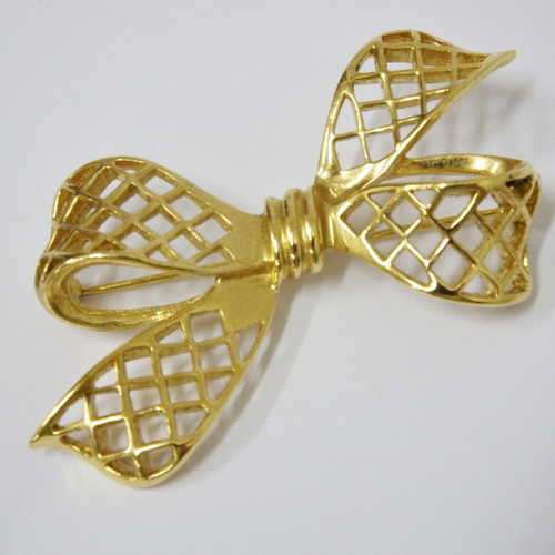 Gold colour brooch in the shape of a bow