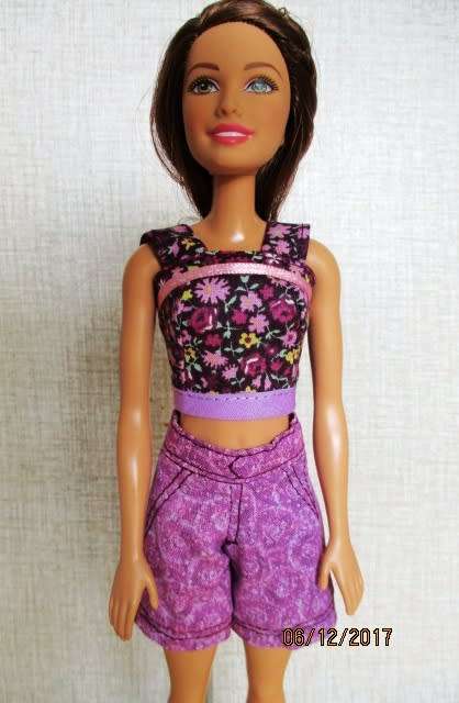 Barbie doll with brown hair and three handmade outfits.