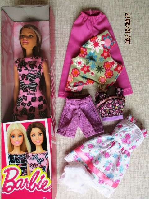 Barbie doll with brown hair and three handmade outfits.