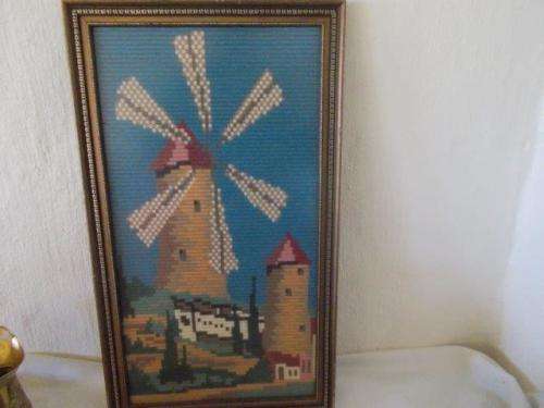 Framed dutch windmill style tapestry behind glass