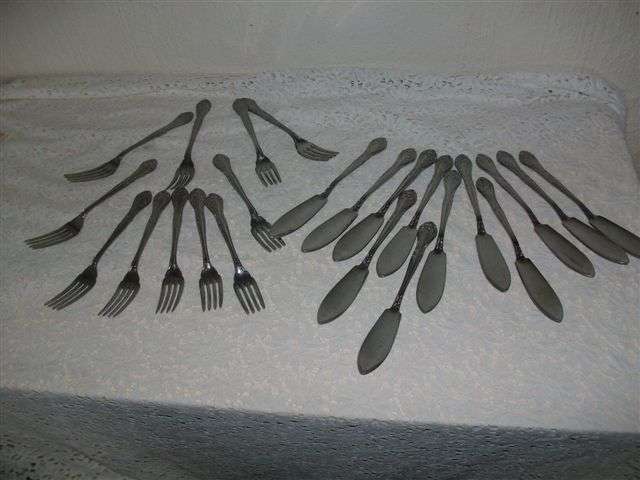 A set of ornate sliver plated fish knifes and forks
