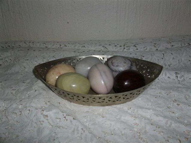 Small sliver plated bowl filled with stone eggs