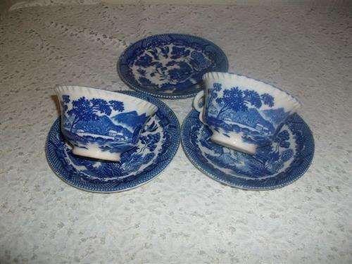 Two lovely willow pattern style tea cups with a extra plate
