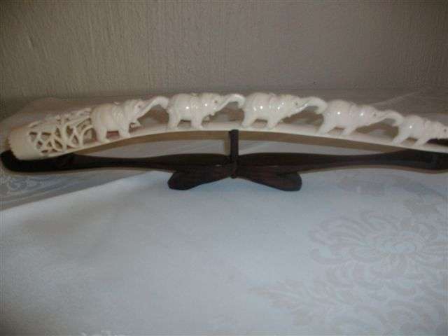 Wonderful craved ivory elephants on tusk on  a wooden stand