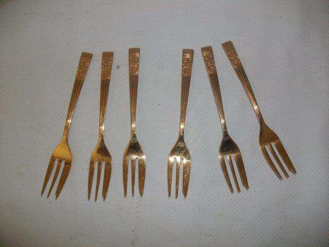 A set of gold plated cake forks