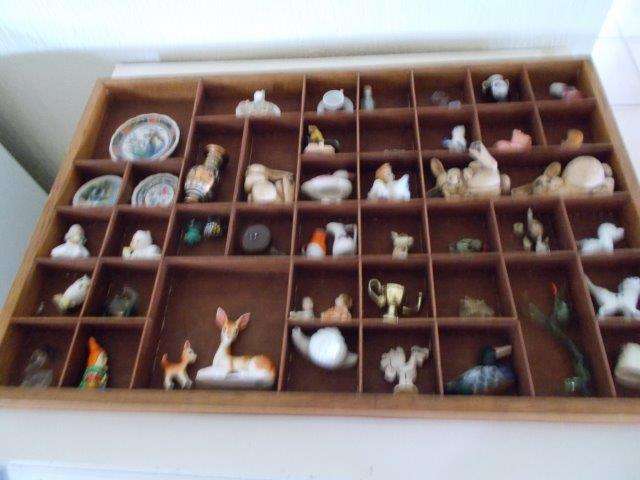 A large printers tray filled with small  ornaments