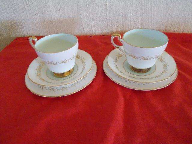 A pair of lovely white and gold trim paragon tea cup trios