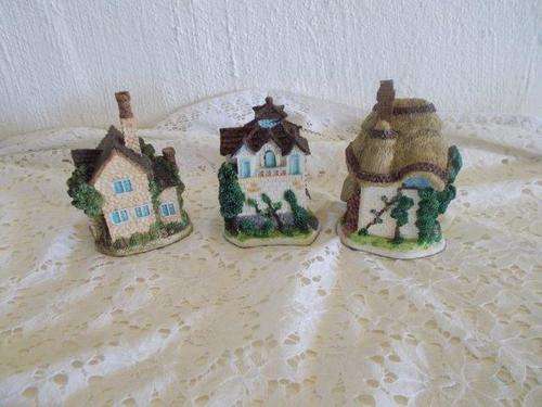 A collection of three small cottage homes ornaments