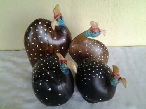 a collection of wooden and other pottery made guinea fowl ornaments
