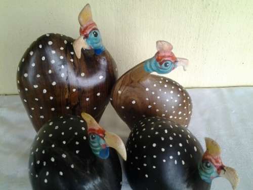 a collection of wooden and other pottery made guinea fowl ornaments
