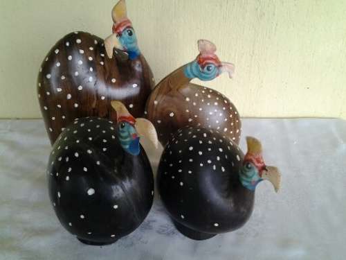 a collection of wooden and other pottery made guinea fowl ornaments