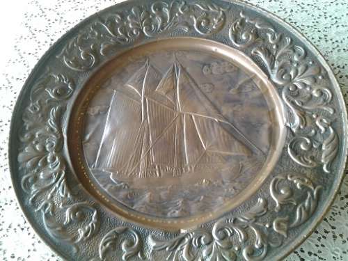 large copper display plate with a ship scene