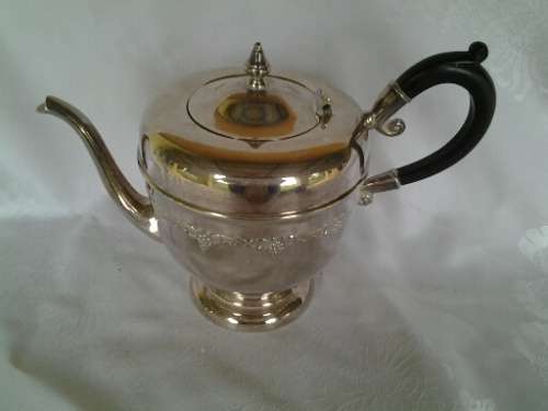vintage sliver plated tea pot with a black handle