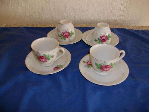 set of four tea cups and saucers with a rose pattern