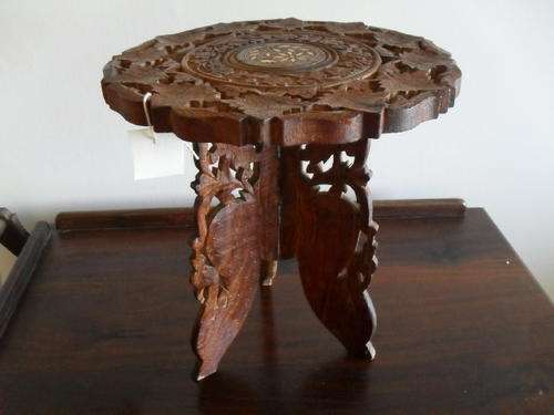 A INTRICATELY CARVED WOODEN TABLE WITH INLAID TOP