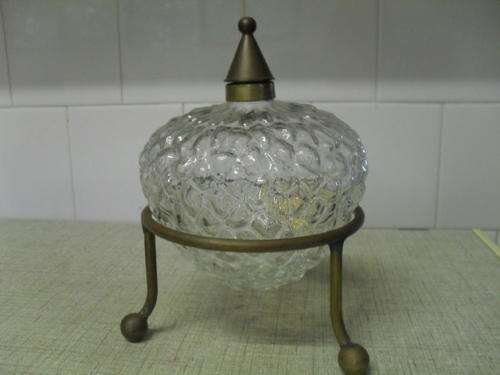 A GLASS LIQUEUR DECANTER with a BRASS COLLAR & LID in a METAL FRAME.