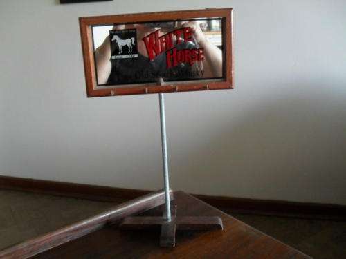 a WHITE HORSE WHISKEY BAR MIRROR ON a wooden STAND with what looks like "car key hooks"