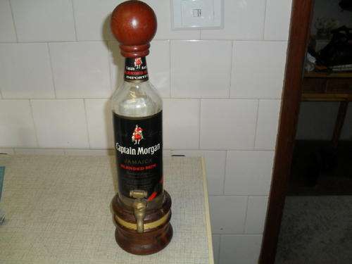 A CAPTAIN MORGAN GLASS BOTTLE DISPENSER / DECANTER / with a brass TAP -mounted on wood.