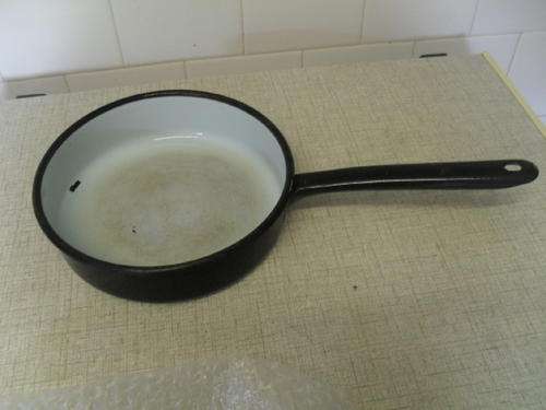 A VINTAGE BLUE and BLACK ENAMEL COOKING PAN -handle 19cm. 20.5cm across.