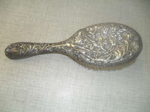 A silver marked repousse hair brush