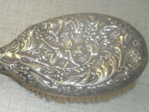 A silver marked repousse hair brush