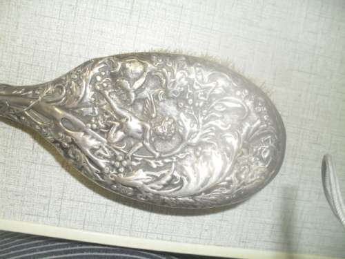 A silver marked repousse hair brush