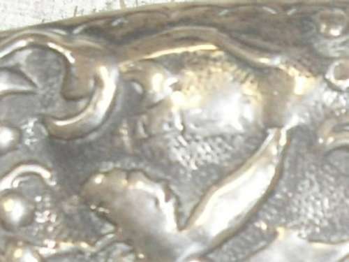 A silver marked repousse hair brush