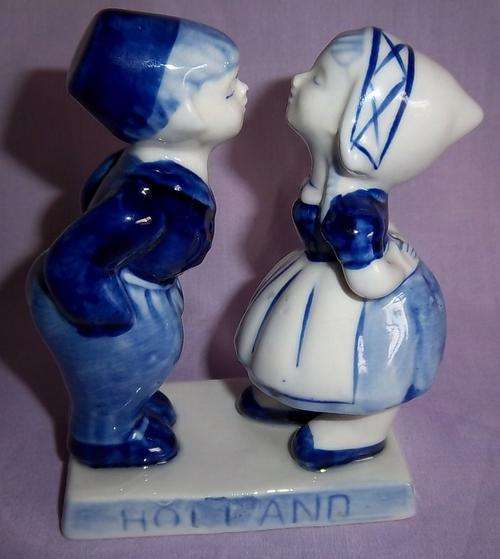 A DELFT BLUE FIGURE OF A BOY AND GIRL ABOUT TO KISS
