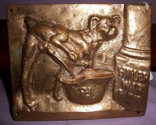 A HEAVY SOLID BRASS WALL PLAQUE DEPICTING A JOKE ABOUT HITLER'S WAR FUND