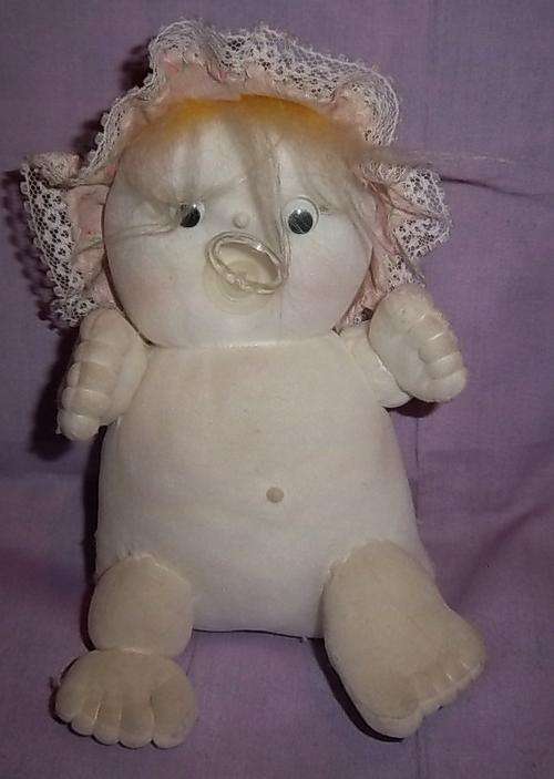 A SMALL WHITE BABY WITH A DUMMY