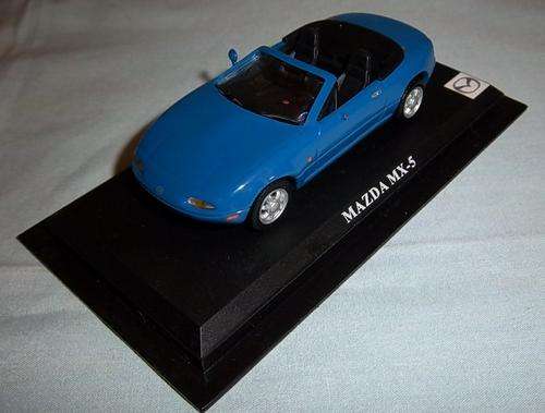 A BLUE MAZDA MX-5 DIE CAST MODEL ON A STAND