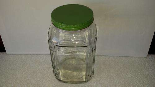 VINTAGE COUNTER GLASS BOTTLE WITH ORIGINAL GREEN TIN LID