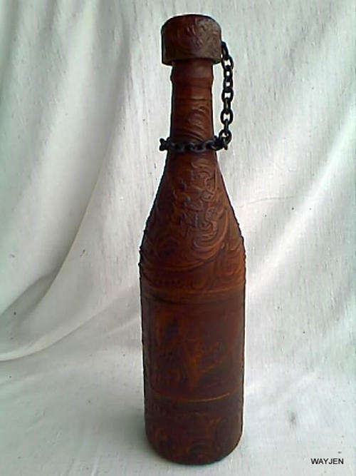 VERY UNIQUE COLLECTORS BOTTLE. 35cm HIGH COVERED WITH LEATHER LIKE MATERIAL INCLUDING CORK ON CHAIN.