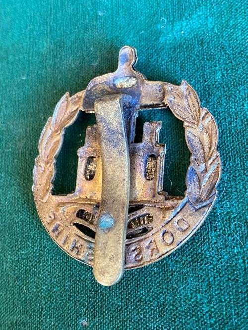 DORSETSHIRE REGIMENT CAP B ADGE WITH SLIDER-WORN 1898-1952