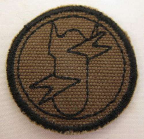 EOD WORK DRESS ROUNDEL.  BLACK THREAD EMBROIDERED ON NUTRIA WITH BLACK MERROWED BORDER
