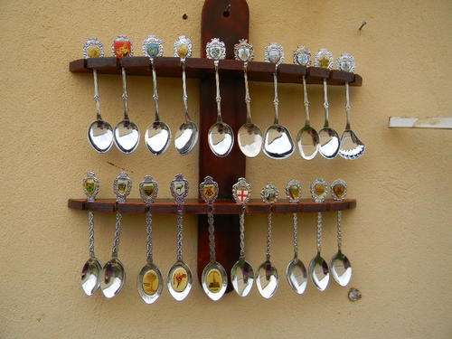 20 Collectable spoons of around the world in excellent condition with rack .
