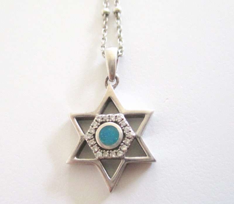A SOLID SILVER STAR OF DAVID PENDANT ON A SILVER CHAIN WITH GRADUATED BALLS