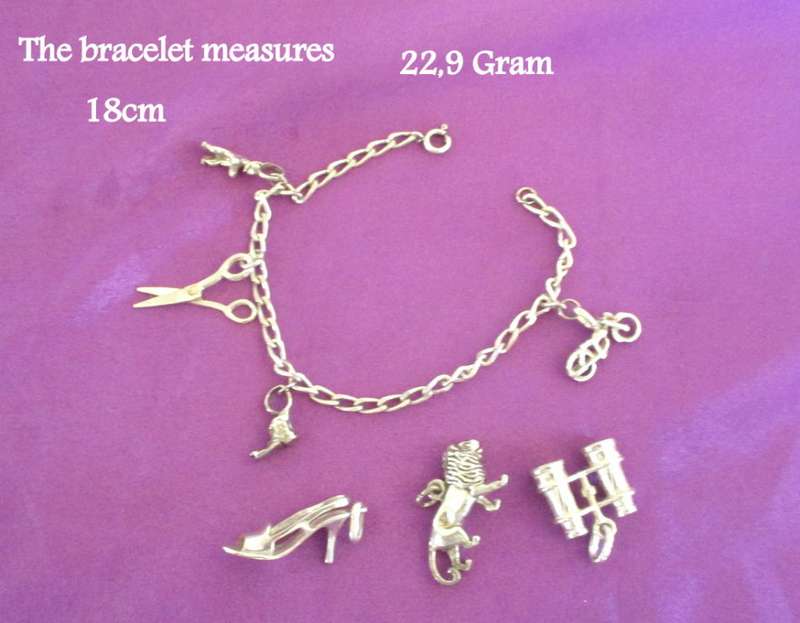 A SOLID SILVER CHARM BRACELET WITH EXTRA LARGER CHARMS